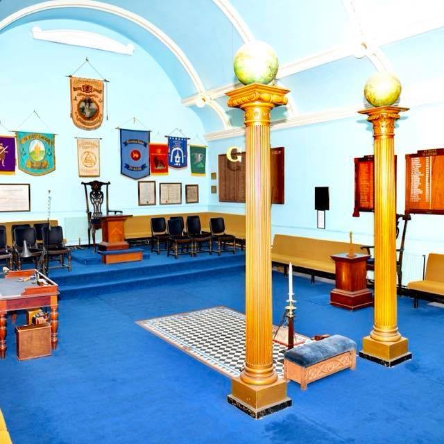The Redruth Masonic Lodge in Cornwall holds its open day on Saturday 9 September 2023. Here its chequered floor and surrounding blue carpet make for an ornate interior set against pillars, plaques and banners
